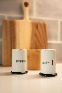 profitable  -two salt and pepper shakers sitting on a counter